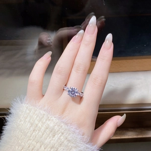 Close-up of 3 carat moissanite ring with six-prong setting on a hand wearing a beige sweater