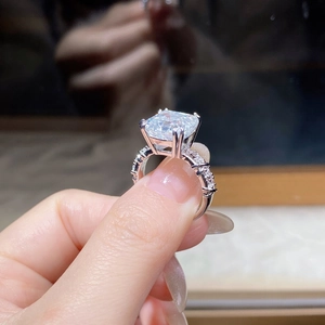 Close-up of a 5-carat Asscher cut moissanite ring with a micro-paved diamond band in S925 silver
