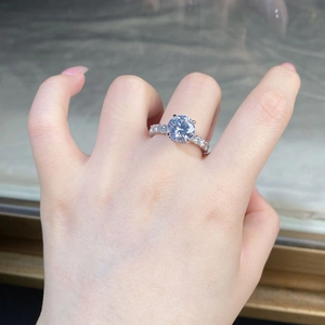 Close-up of 3 carat moissanite ring with side stones on a finger for wedding style