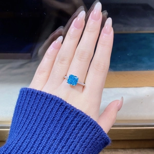 Close-up of S925 silver ring with radiant cut blue stone and pavé set side diamonds