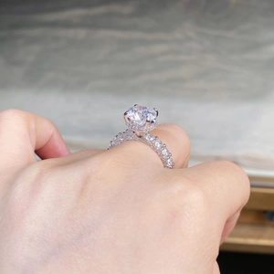 Macro detail of 3 carat round moissanite ring with halo setting and pave diamond band