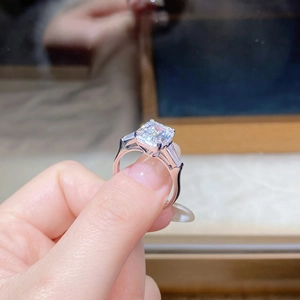 Macro shot of 4 carat emerald cut moissanite ring with side stones on S925 silver