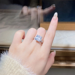 Macro shot of 5ct Asscher cut moissanite ring with diamond accents on a silver band