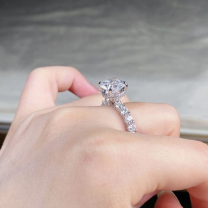 Detailed side view of 3ct moissanite ring with six-prong setting and pavé diamonds