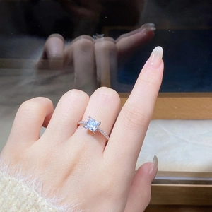 Detailed close-up of a square princess cut moissanite ring in 925 silver four-prong setting