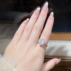 Detail of 4 carat emerald cut moissanite ring with side micro-pave setting on hand