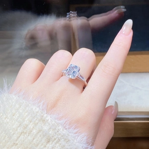 Detail of 4ct emerald cut moissanite ring in silver S925 on finger with mirror reflection