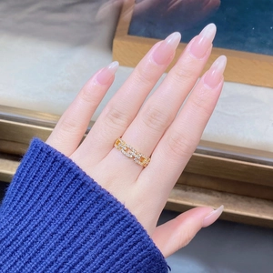 Detail of gold chain ring with sparkling zircons worn elegantly on hand