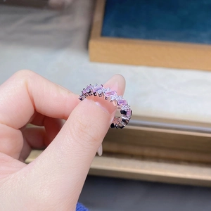 Gros plan d'une bague en argent sertie de zircons roses taille émeraude et cristaux