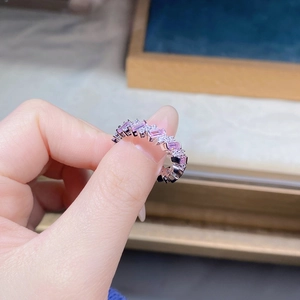 Gros plan d'une bague en argent S925 avec pierres roses taille émeraude et diamants
