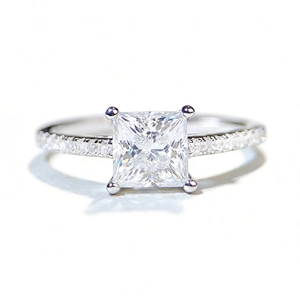 Princess cut moissanite ring with four-prong setting and pavé side stones on 925 silver band