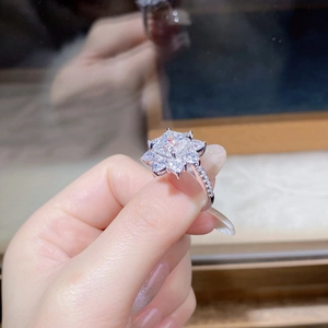 Vue macro d'une bague solitaire coussin avec halo en forme de poire sur la main