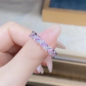 Gros plan sur bague en argent avec gemmes roses taille émeraude et pavé de diamants