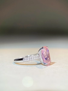 Macro di un anello in argento con zaffiro rosa ovale e pavé di zirconi scintillanti