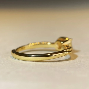 Macro side view of gold ring featuring intricate beaded edges and side-set diamonds