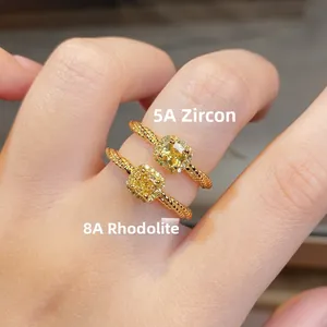 Macro detail of yellow radiant cut zircon rings with twisted rope gold bands on finger