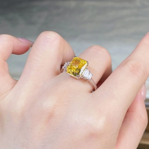 Détail macro d'une bague avec pierre jaune taille radiant et anneau argent