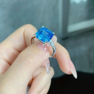 Macro view of Asscher cut blue gemstone ring with pave diamonds on S925 silver band