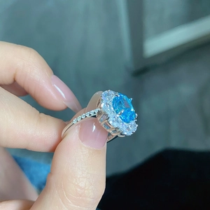 Detail of S925 silver oval blue gemstone ring with Au750 stamp and halo diamonds