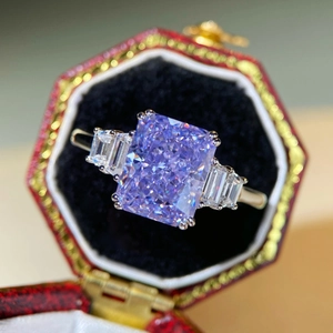 Macro shot of Radiant-cut lavender gemstone ring with side stones in a luxury gift box