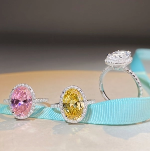 Bagues halo ovales avec diamants roses, jaunes et blancs sur ruban de soie bleu