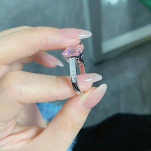 Macro view of S925 silver ring featuring a large emerald cut pink diamond and side stones
