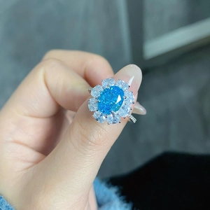 Detailed close-up of oval light blue gemstone ring with small clear diamonds in S925 silver
