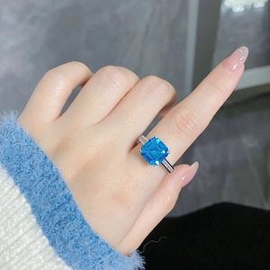 Macro shot of a S925 silver ring featuring a square blue sapphire-like gemstone and diamonds