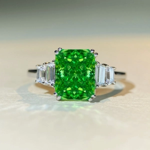 Macro shot of Radiant cut emerald green zircon ring with trapezoid side stones in S925 silver