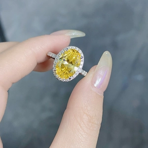 Macro shot of oval cut yellow gemstone ring with a brilliant halo and diamond band