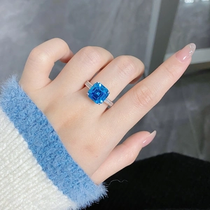 Macro shot of S925 silver ring with emerald-cut blue gemstone and side diamonds