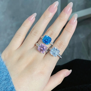 Close-up of S925 silver rings with Asscher cut pink and blue zircon stones on hand