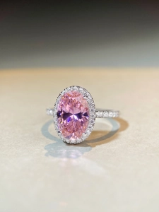 Détail macro d'une bague diamant rose ovale avec halo étincelant et anneau en argent