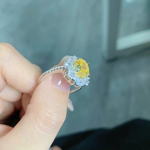 Macro shot of S925 silver ring featuring an oval yellow diamond in a halo setting