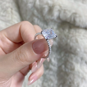 Close-up of a 4-carat emerald-cut zircon ring with micro-pave diamonds on 925 silver