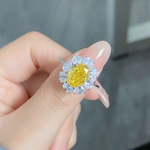 Macro detail of S925 silver flower ring featuring an oval yellow gemstone and halo diamonds