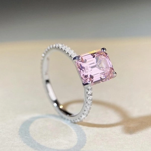 Macro view of emerald-cut pink zircon ring in silver finish with pavé set accents