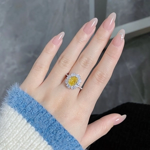 Detail of sunflower sterling silver ring with yellow oval gemstone worn by a model