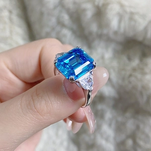 Vue macro d'une bague avec pierre bleue taille émeraude et zircons latéraux en argent