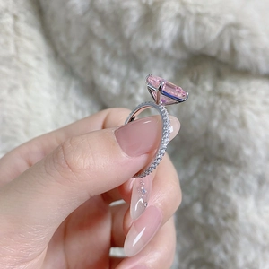 Macro shot of silver ring with large rectangular pink gemstone and micro-pave diamonds