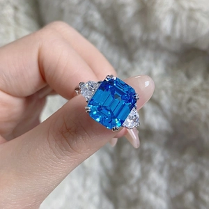 Détail macro d'une bague aigue-marine taille émeraude avec pierres latérales en forme de poire