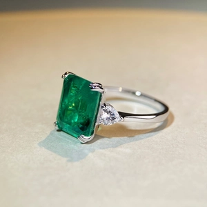 Rectangle emerald ring with pear-cut side diamonds in polished silver band setting