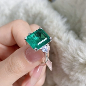 Close-up of S925 sterling silver ring with emerald cut green stone and side stones