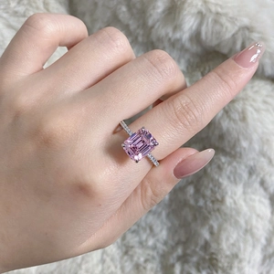 Close-up of S925 silver ring featuring emerald-cut pink zircon on plush background