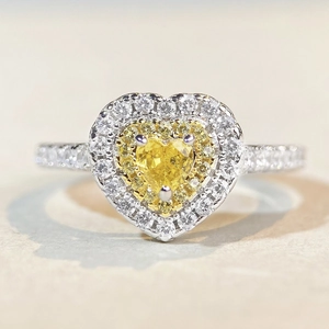 Détail macro de bague coeur avec pierre jaune et double halo de zircons blancs pavés