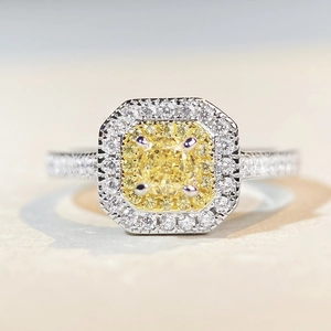 Macro shot of silver ring featuring double halo yellow cushion cut gemstone with side diamonds