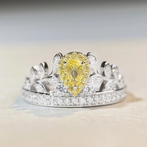 Détail d'une bague couronne en argent S925 avec une pierre jaune en poire et petits diamants