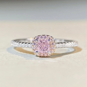 Macro view of cushion cut pink zircon ring with halo setting and pavé diamond band