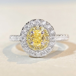 Close-up of a double halo ring with oval yellow gemstone and sparkling pavé diamonds