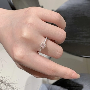 Detailed view of a square pink sapphire ring with halo diamonds on a hand